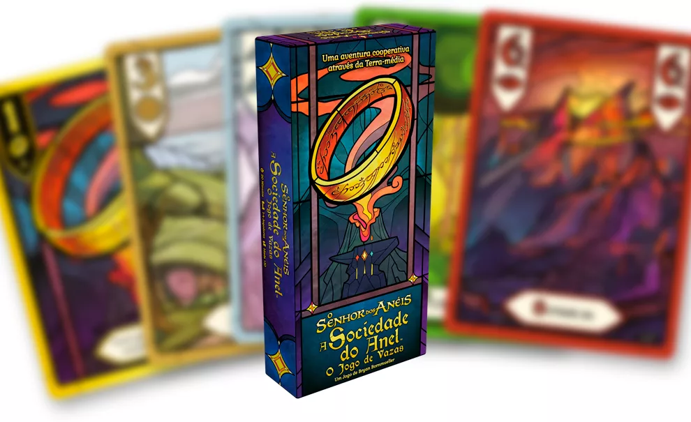 Caixa do jogo O Senhor dos Anéis: a Sociedade do Anel - O Jogo de Vazas e ao fundo as cartas desfocadas.