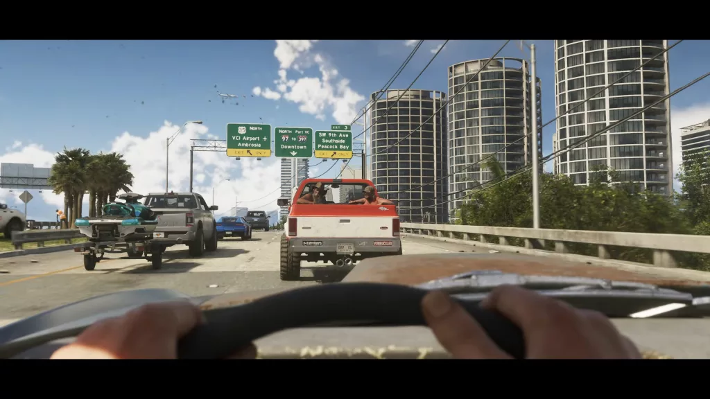Mãos no volante e uma vista para a estrada com vários carros.