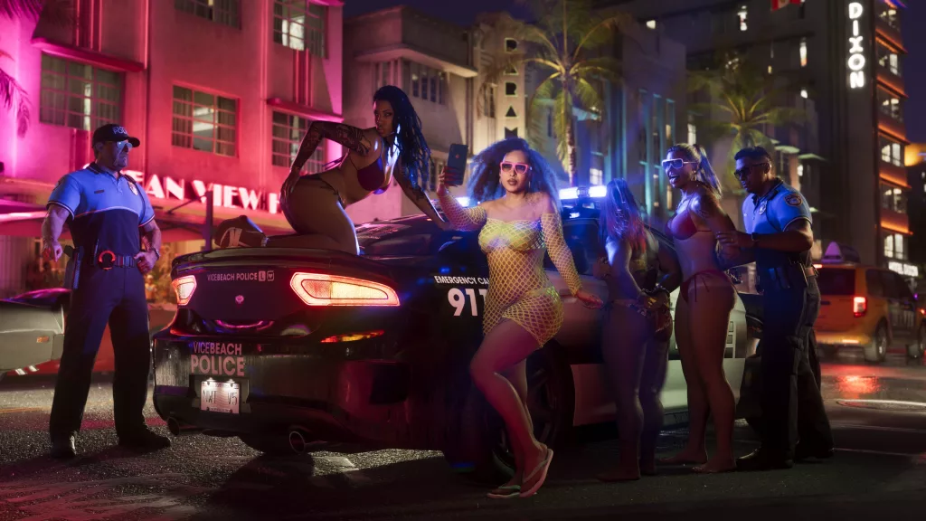 Garotas de biquini sendo presas por 2 policias, mas elas dançam em cima do carro deles.