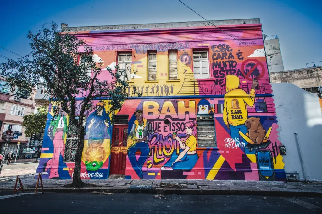 Mural de Valorant em prédio em frente a uma rua com uma árvore.