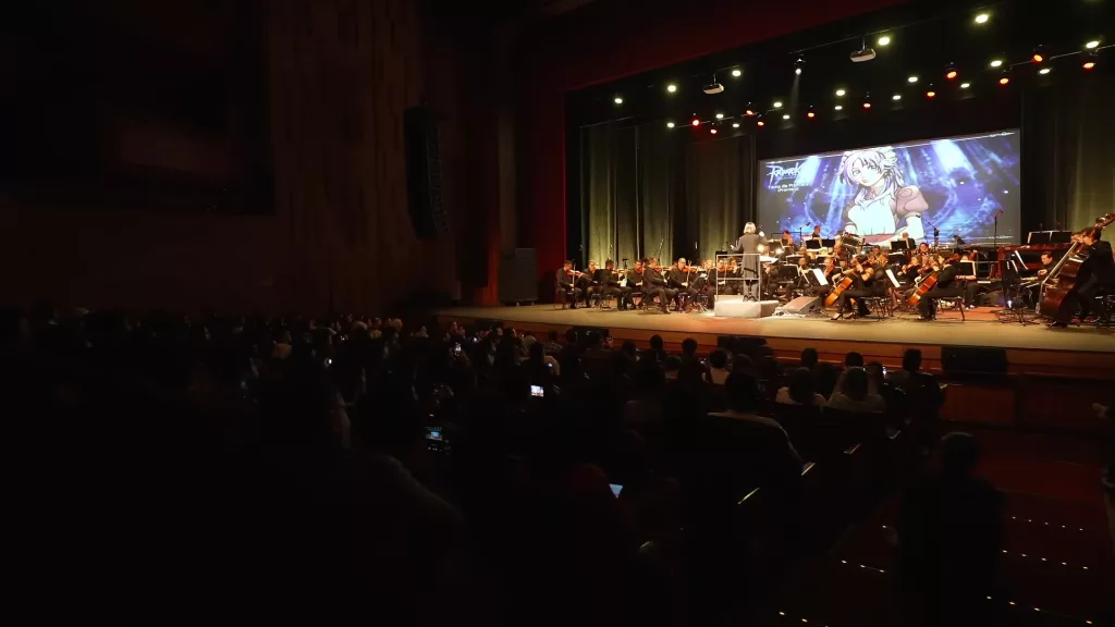 Imagem de cima mostrando palco e público na apresentação.