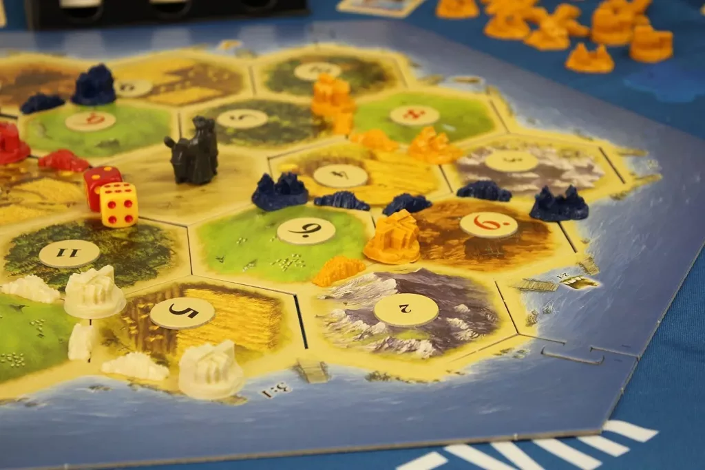 Parte do tabuleiro de Catan e suas peças.