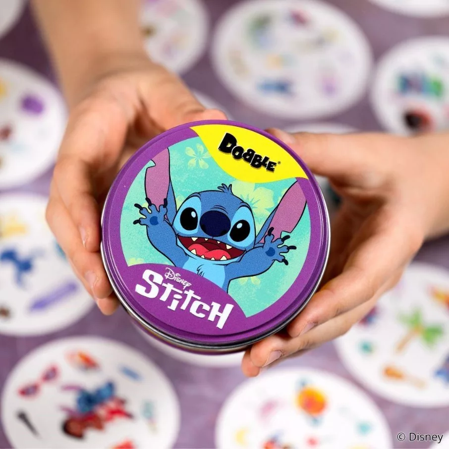 Mãos apresentam uma caixa circular metálica com a versão Dobble Stitch da Galápagos e Disney.