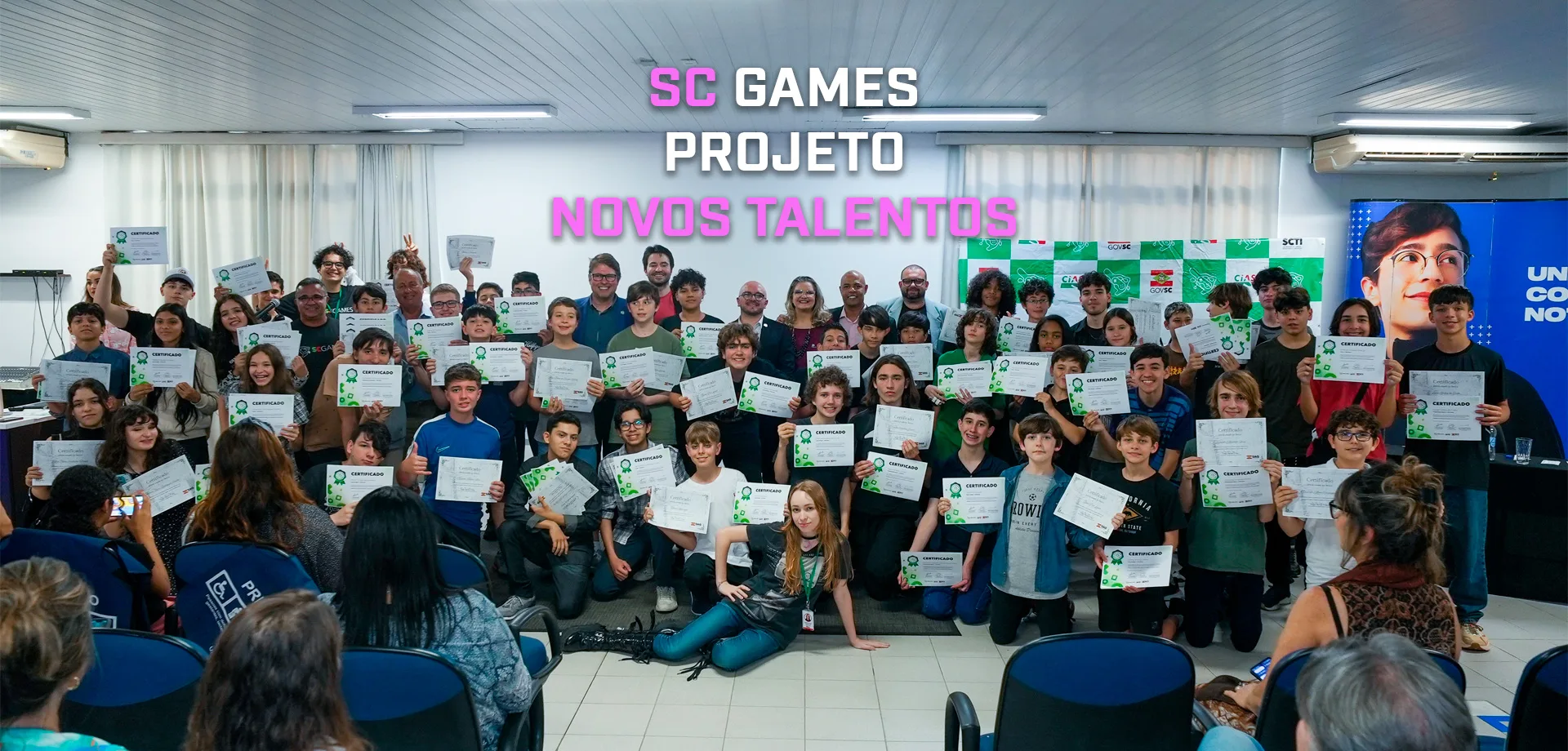 Jovens do Projeto Novos Talentos do Programa SC Games com seus certificados e acompanhados dos adultos que ajudaram no aprendizado.