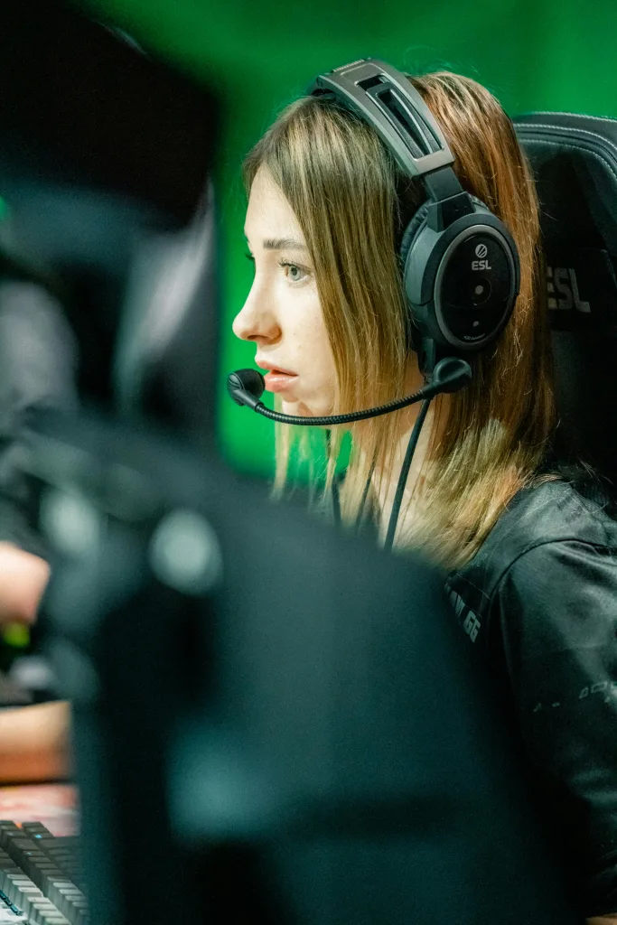 Mulher com headset concentrada em jogo.