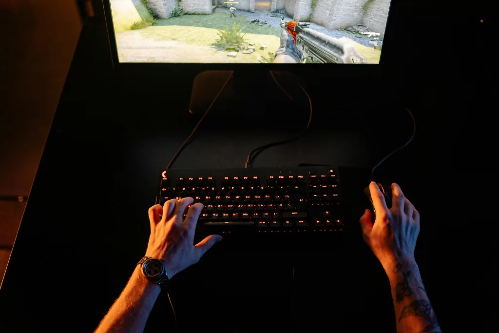 Mãos de uma pessoa sobre um teclado, jogando Counter Strike.