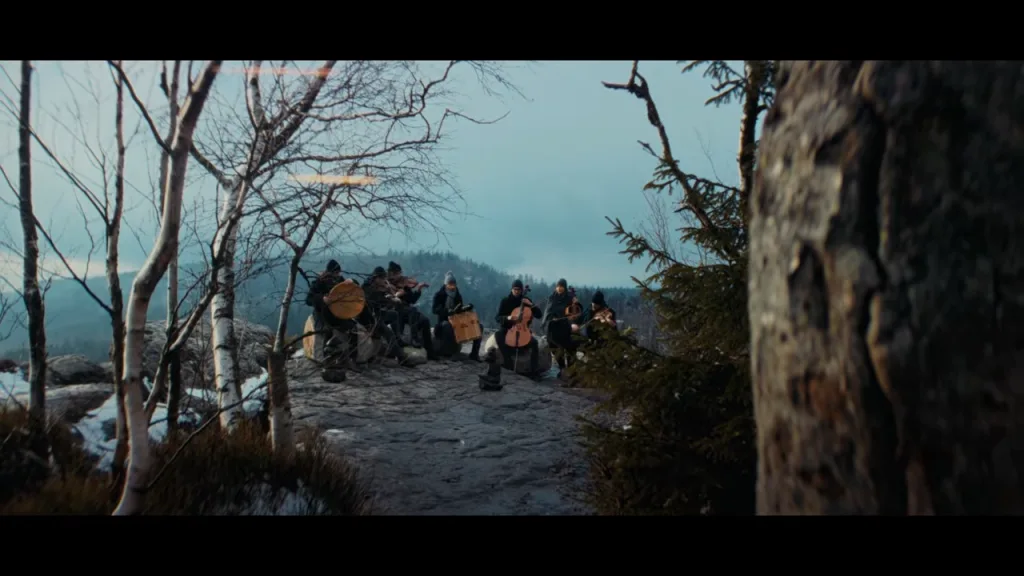 Grupo de músicos tocando "Uphill Battle" em montanha durante o evento de The Blood of Dawnwalker