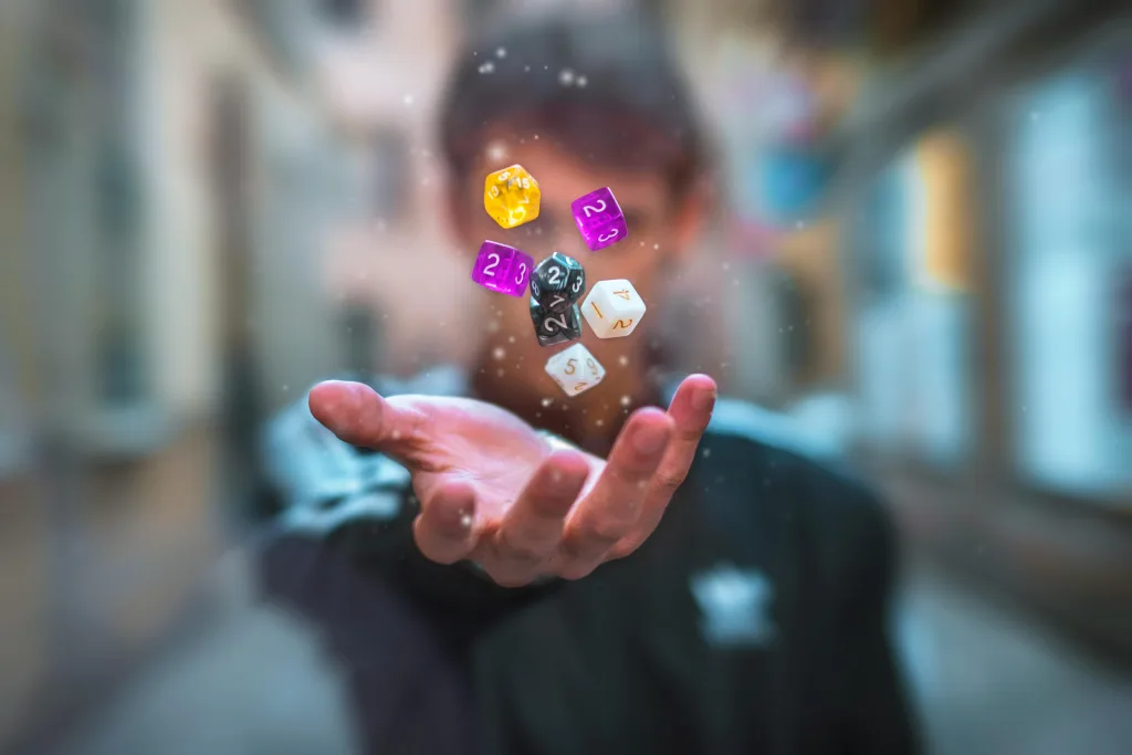 Dados de RPG lançados ao ar por homem desfocado ao fundo.