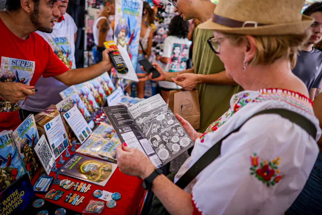 Expositores e clientes vendo quadrinhos no Passeio Geek.