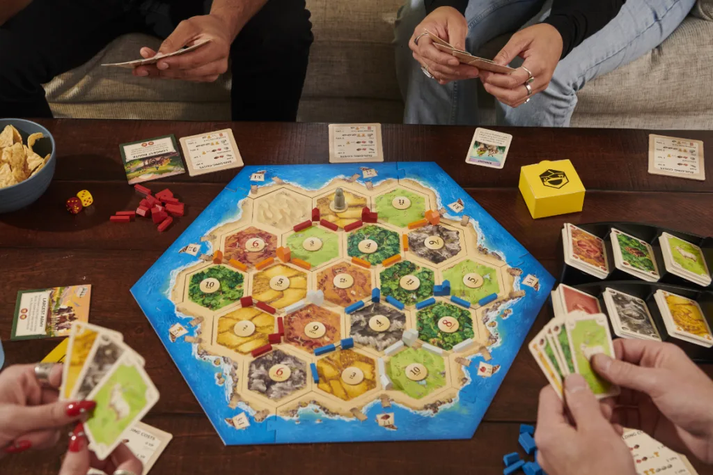 Pessoas jogando o Boardgame CATAN.