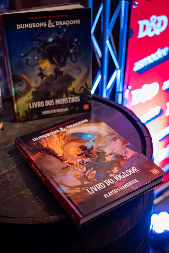 Livro do jogador de Dungeons & Dragons deitado na superfície de um barril e Livro dos Monstros em pé.