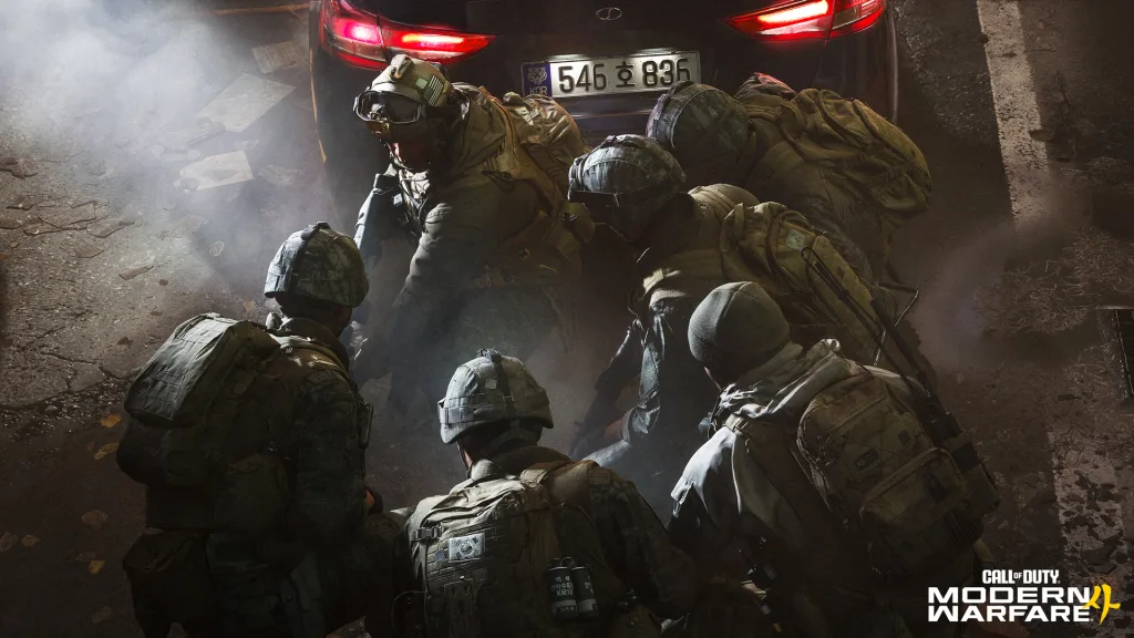Grupo de soldados Sul-Coreano junto de soldado estadounidense atrás de carro durante ataque.