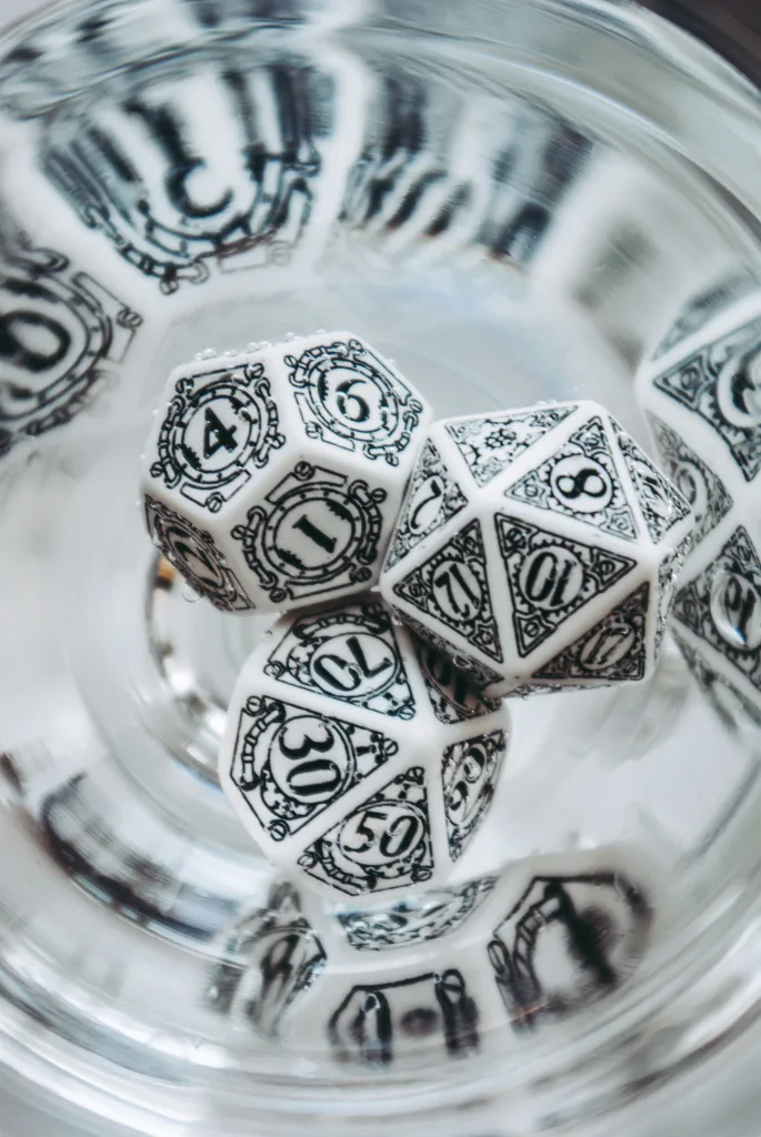 Dados de RPG em copo de vidro.