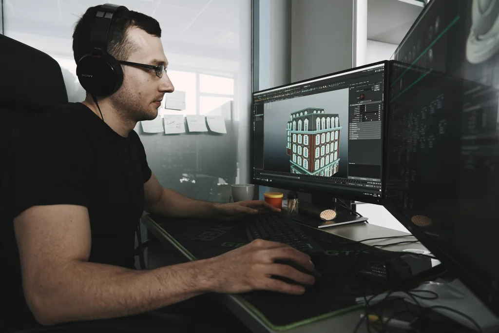 Homem em computador trabalhando em construção de cenário na indústria de games.