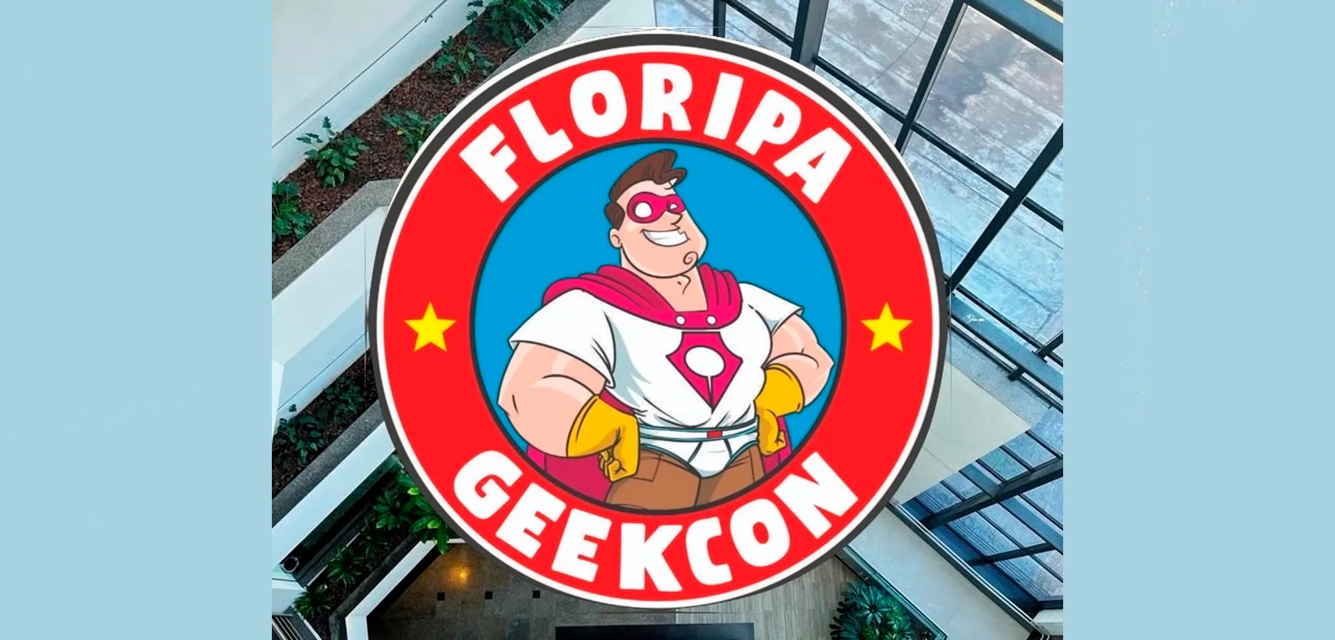 Logo da Floripa Geekcon 2026 com fundo de foto de um prédio.